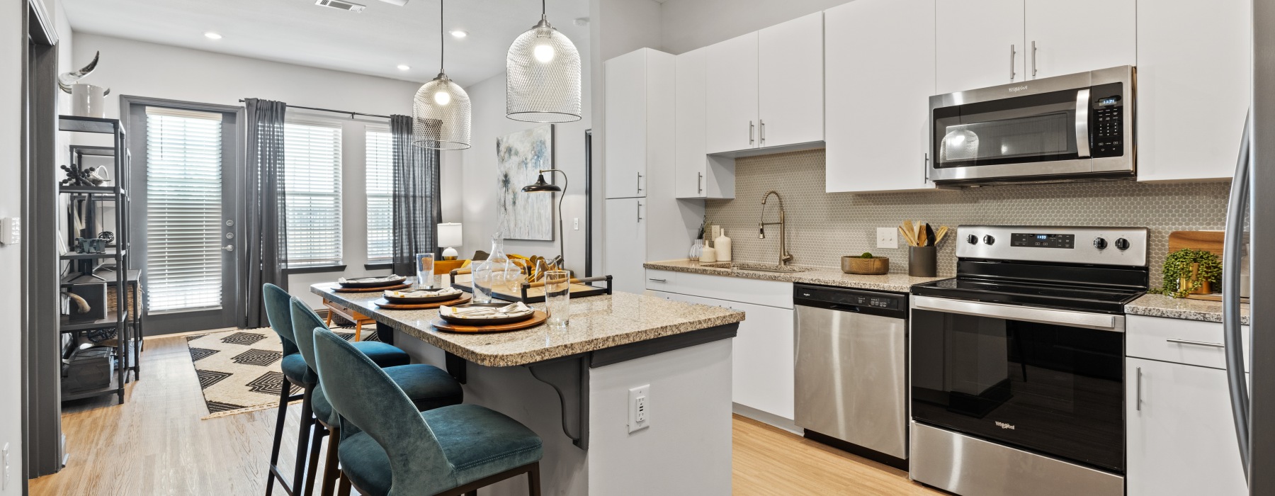 Bright open concept kitchen with island seating and stainless steel appliances at Westhouse Apartment Flats Fort Worth